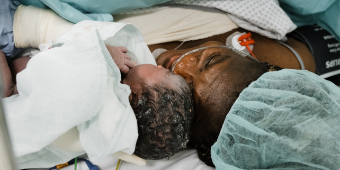 Eine Mama begrüßt ihr Neugeborenes liebevoll nach dem Kaiserschnitt