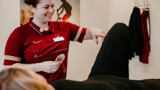 Physiotherapeutin behandelt am Knie