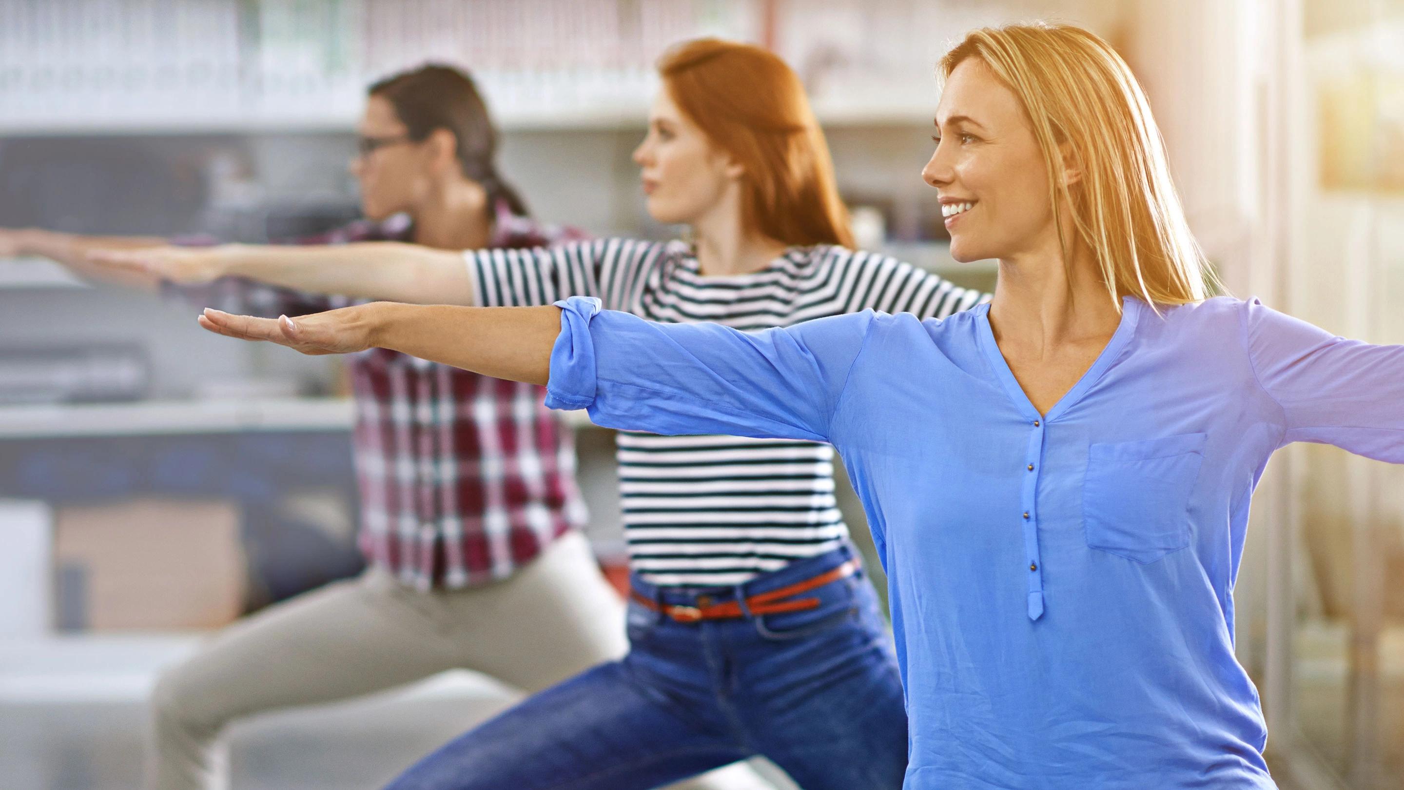 Bild: Frauen in Bürokleidung machen Yoga