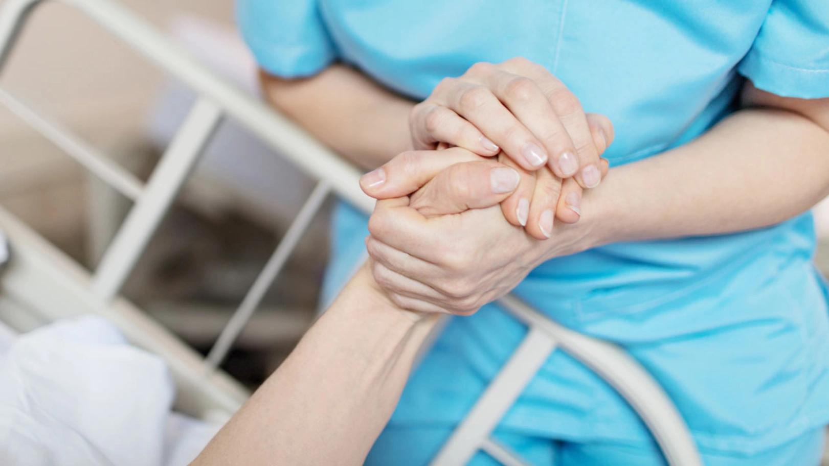 Bild: Pflegefachfrau hält Hand der Patientin